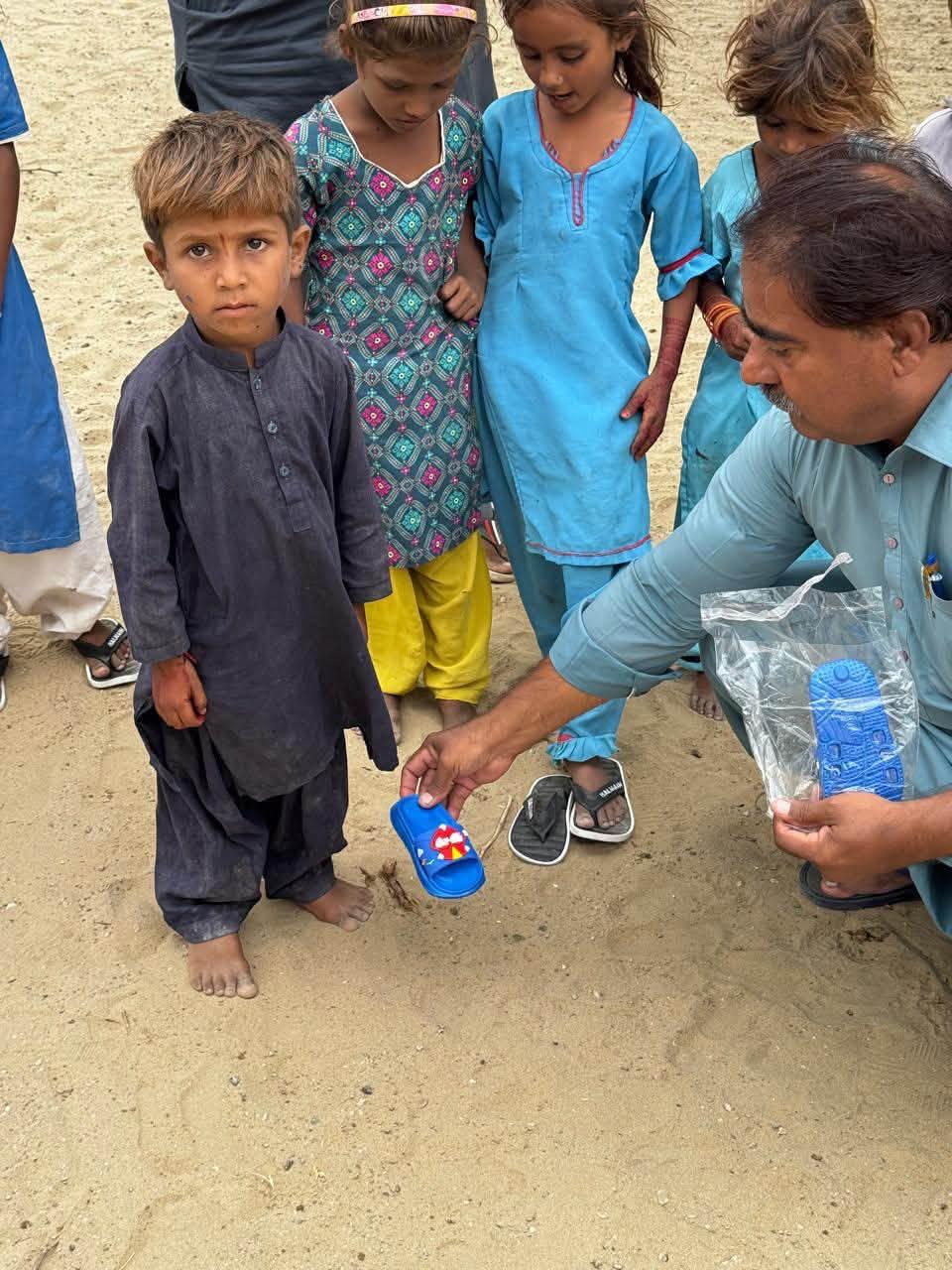 Footwear being provided to a young child during community outreach